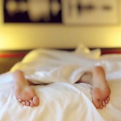 feet of a person laying face down in a bed