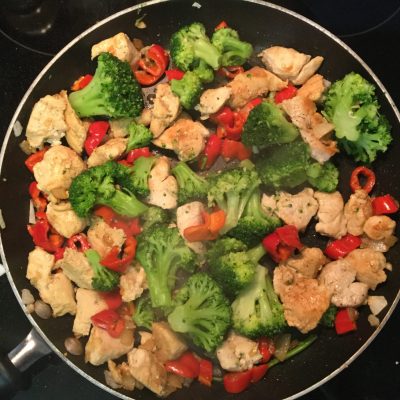 a pan full of chicken, broccoli and red peppers