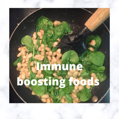 beans and spinach in an oiled pan with a spatula with text reading 'immune boosting foods'